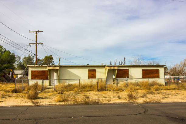Abandoned One Story Duplex With Boarded Up Windows Abandoned Overgrown One Level Duplex With Boarded Up Windows duplex photos stock pictures, royalty-free photos & images