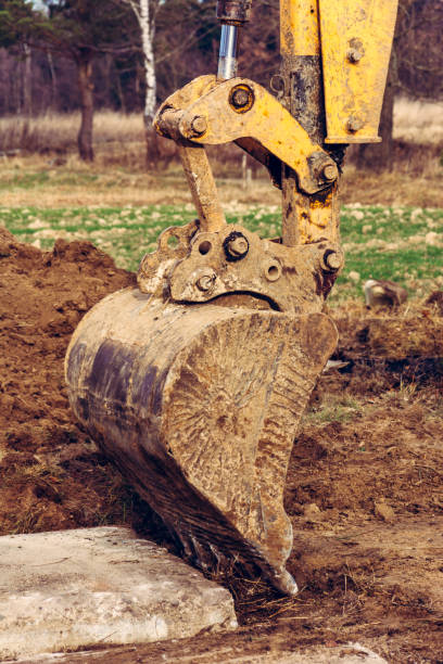 istock A yellow excavator works on the forest clearing and digs soil. 1198839911