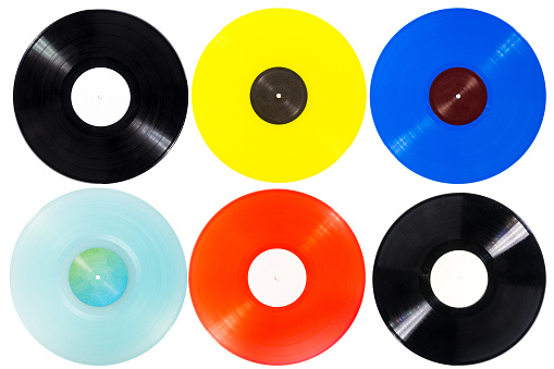 Collection of various color vinyl records with paper labels isolated on white background.