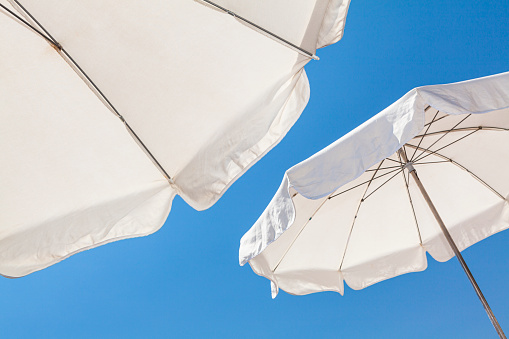 White umbrellas against a blue sky on the French Riviera.