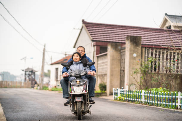 asian father and daughter riding an electric bike - ten speed bicycle imagens e fotografias de stock