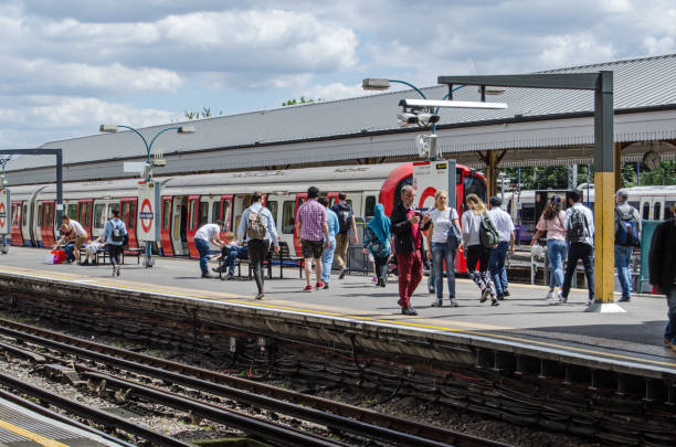 Passengers at Ealing Broadway Station, London London, UK - June 22, 2019:  Passengers waiting for a District Line train at Ealing Broadway Station in West London on a sunny summer day. eanling stock pictures, royalty-free photos & images
