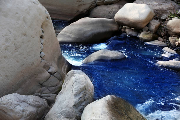 Beautiful scenic view of flowing water between stones in Uttarakhand, India.