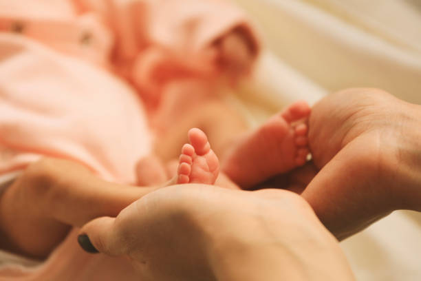 Hand the sleeping baby with mother hand