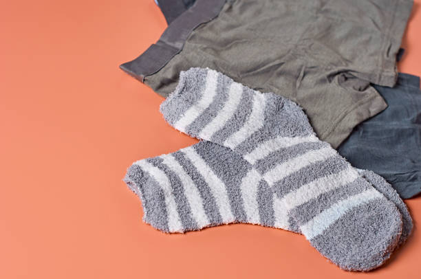 istock Striped soft and warm socks and new dark underpants on orange background. Space for text 1198845851