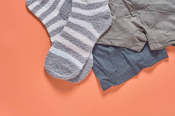 istock Striped soft and warm socks and new dark underpants on orange background. Space for text. Top view 1198845861