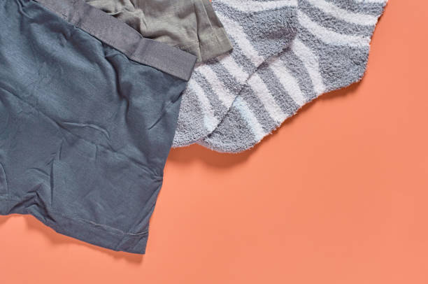 istock Striped soft and warm socks and new dark underpants on orange background. Space for text. Top view 1198845862