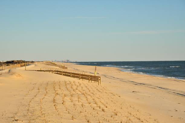 Assateague Island Winter Beach and Skyline A winter beach scene on the Maryland Assateague Island State Park with access walkways, dune restoration and the Ocean City skyline on the horizon 10 miles away, eastern shore sand sand dune beach stock pictures, royalty-free photos & images