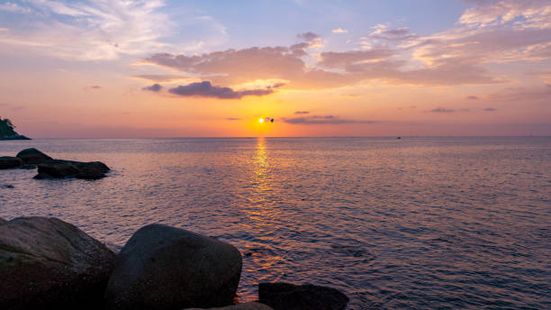istock Dramatic sky seascape with rock in the foreground sunset scenery nature background. 1198848155