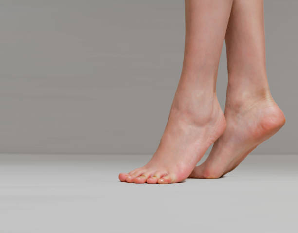 istock Slender female legs raised on toes on a light gray background 1198850692