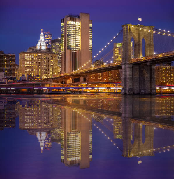 brooklyn bridge and manhattan municipal building reflected in east river at sunset, new york, etats-unis. - east river drive photos et images de collection