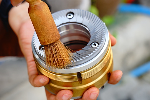 Cleaning grinding wheel of Coffee grinder by Dust brush