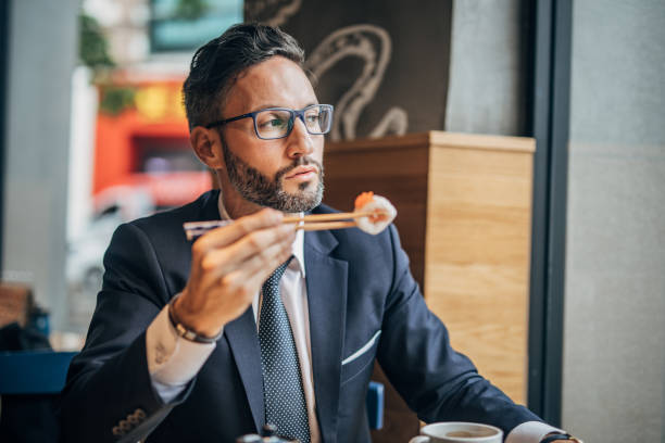 istock Man eating sushi in the restaurant 1198852854