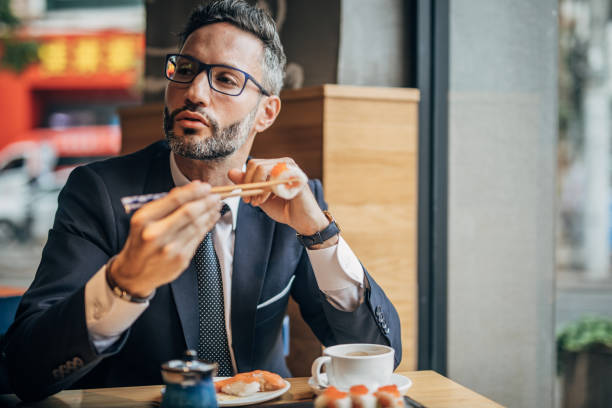 istock Man eating sushi in the restaurant 1198852924