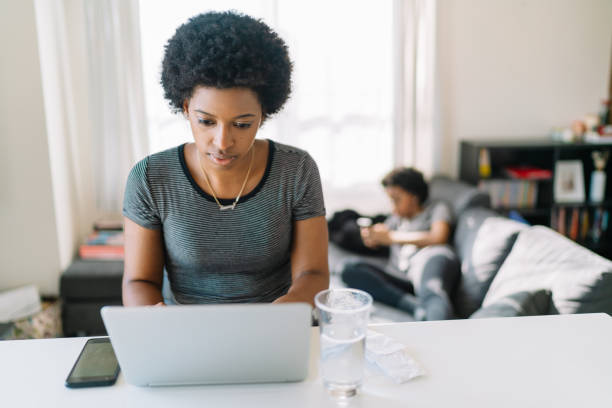 istock Young and beautiful black woman using laptop at home 1198853614