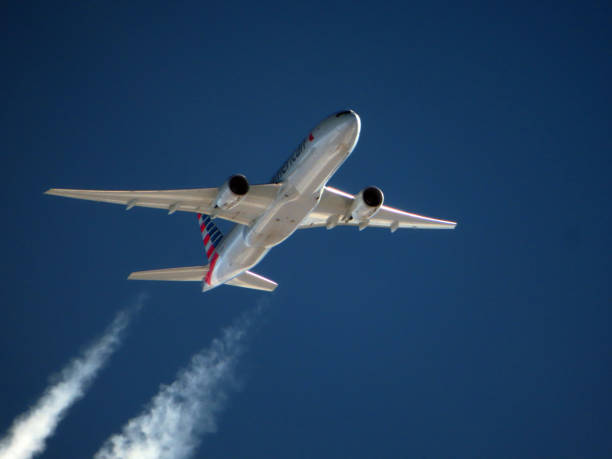 American Airlines AMR Boeing 777-200 In-flight Contrails Air travel stock photo