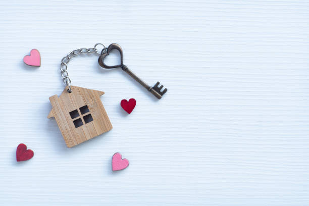 House key in heart shape with home keyring on old wood background decorated with mini heart, home sweet home concept, copy space House key in heart shape with home keyring on old wood background decorated with mini heart, home sweet home concept, copy space book heart shape valentines day copy space stock pictures, royalty-free photos & images