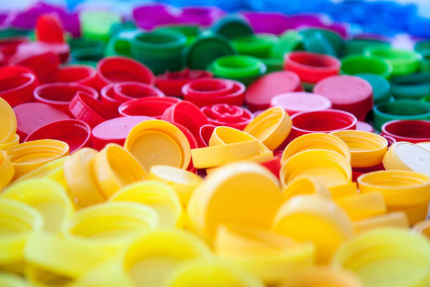 istock Plastic caps in different colors on white wooden table. 1198856160