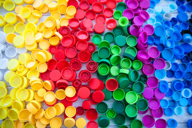 istock Plastic caps in different colors on white wooden table. 1198856164