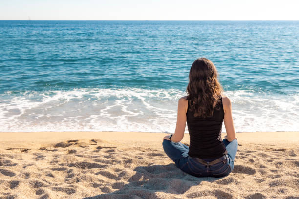 istock Girl meditating in the beach 1198858539