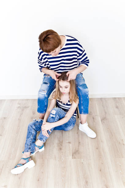 istock Mother is making hairstyle to her daughter 1198859823