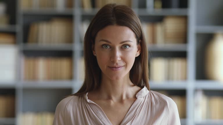 Smiling attractive young woman looking at camera, slow motion portrait