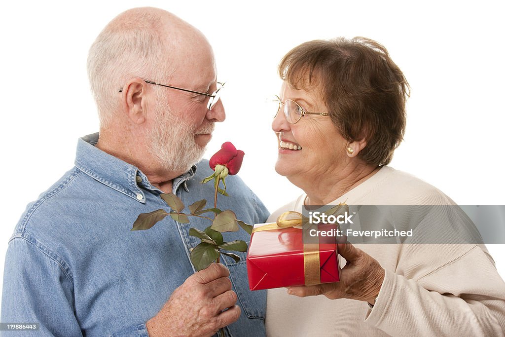 Felice coppia Senior con regalo e rosso rosa - Foto stock royalty-free di 70-79 anni