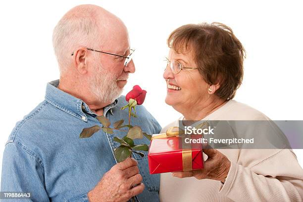 Felice Coppia Senior Con Regalo E Rosso Rosa - Fotografie stock e altre immagini di 70-79 anni - 70-79 anni, Abbigliamento casual, Adulto