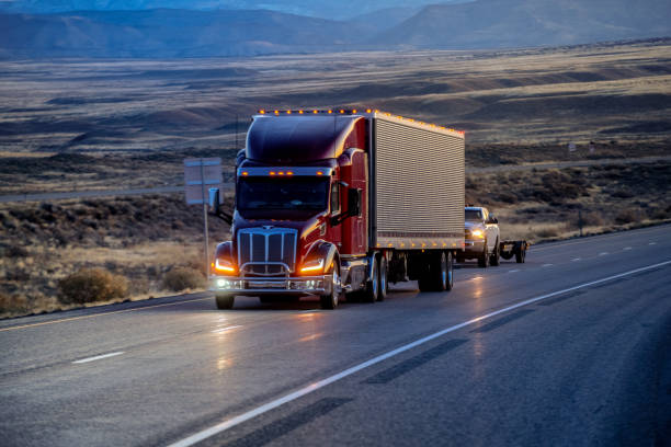 long haul semi truck speeding down a four lane highway to delivery their loads - four lane highway stock-fotos und bilder