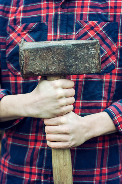 istock A young man holding an old ten-kilo hammer. 1198867791