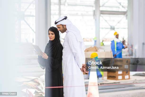 Abu Dhabi Construction Professionals Collaborating Onsite Stock Photo - Download Image Now