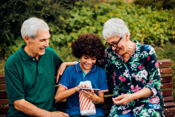 istock Boy and his grandparents enjoying outdoors and using a smartphone 1198881434