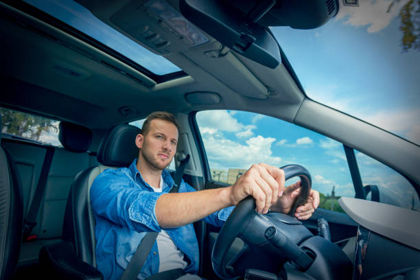 istock Young man driving a car. 1198882567