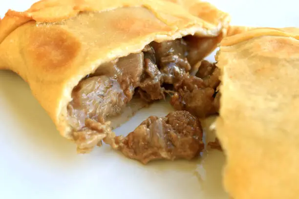 Photo of Empanada de Pino or beef filled Empanada, delicious Chilean baked savory pasty served on white plate