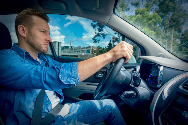 istock Young man driving a car. 1198882597
