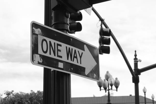 istock One way sign hanging on a pole on a crossroad traffic light 1198884032