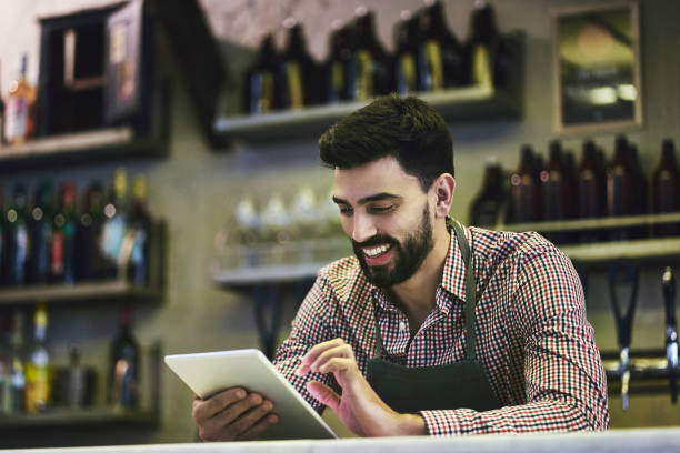 istock Buenos Aires Man Using Digital Tablet Behind Bar Counter 1198884694