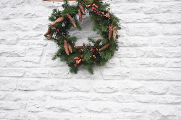 istock christmas wreath decorated on white wall 1198890850