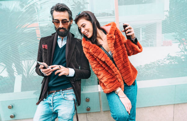 istock Modern hipster couple having fun using mobile smart phone outside - Social interaction concept with friends sharing digital content on social media networks - Millenial generation dating online 1198891126