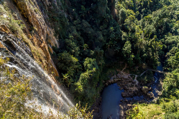 istock Bright waterfall flowing down rockface to rockpool below 1198891250