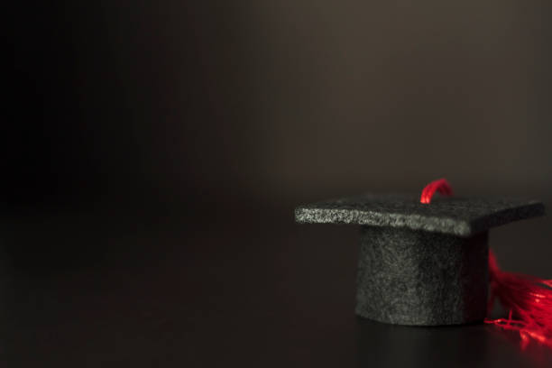 istock Graduation cap on black background with copy space 1198901125