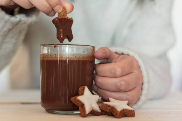 istock Woman hands dipping cookie in hot chocolate 1198901149