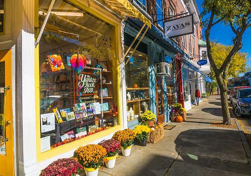 Woodstock, Vermont, USA-October 18, 2017-Colorful pots of chrysanthemum, enhance  the window display of the Yankee Book Shop on Central Street. Known as “Vermont’s oldest continuously run bookstore.”  small independent book stores such as this are thriving in spite of on line competition.