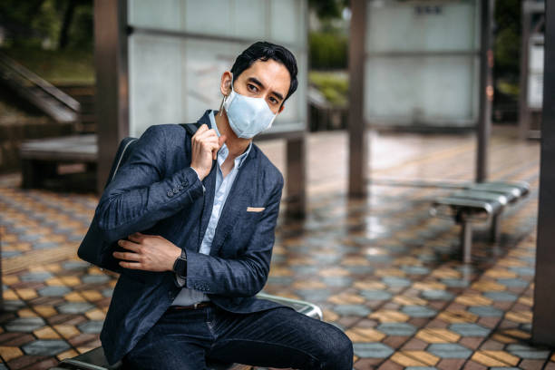 istock Businessman sitting on bust stop 1198910180