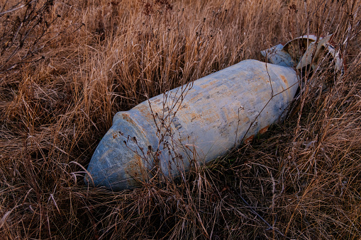 Unexploded bomb in the grass, war and peace concept.