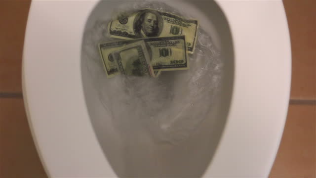 Flushing dollars in toilet bowl in slow motion 250fps