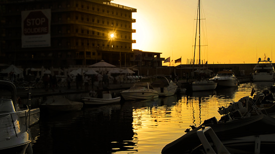 Sunset at Lebanon's largest seaport, located in the country's capital, Beirut, Mediterranean Sea. Buildings, maritime transports and the reflection of the sun in the water of the Mediterranean Sea bathing the peninsula. Tone of yellow and orange colors composes the late afternoon in this beautiful city and is part of the urban center.