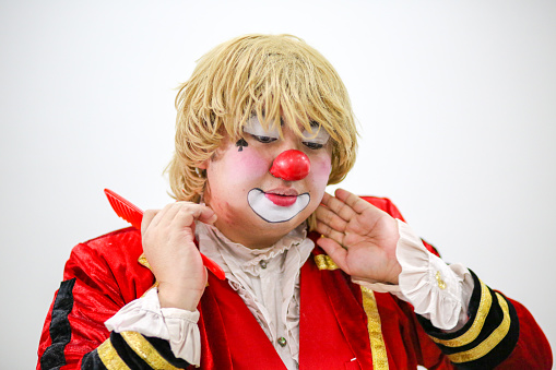 Portrait of a clown performer - using comb to comb his wig neatly.
