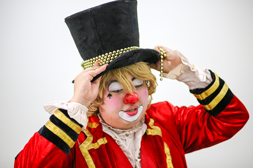 Portrait of a clown performer - fixing his tall hat.