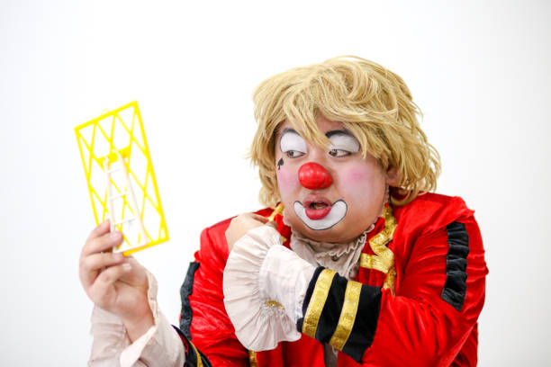 Portrait of a clown performer - using mirror to fix his wig.